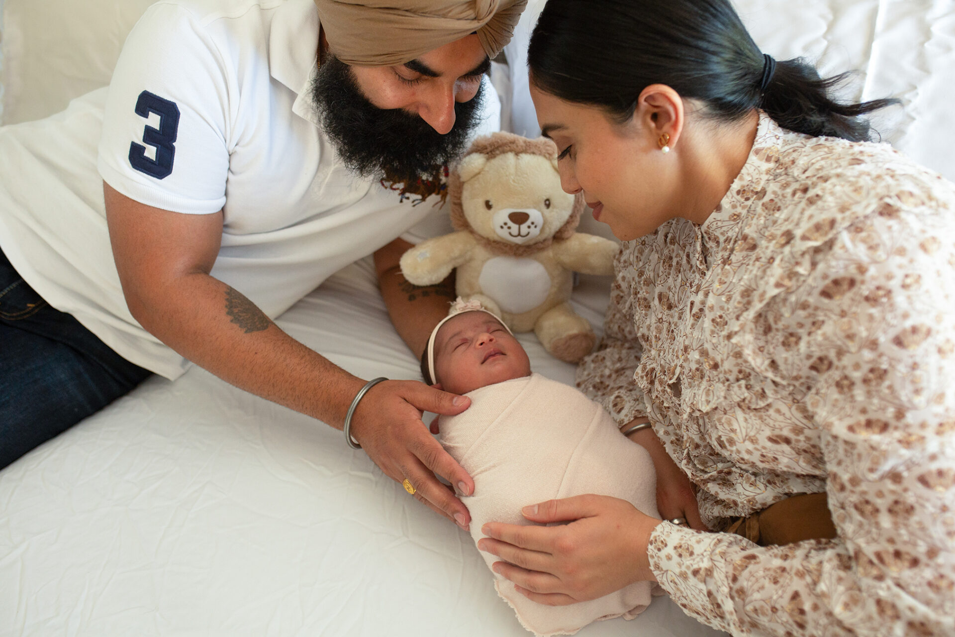 Parents holding newborn during in-home session in Roseville CA