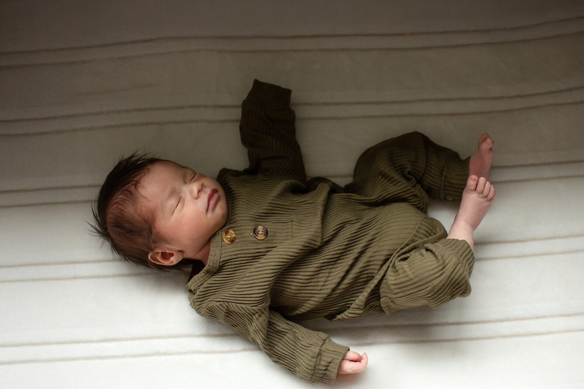 Newborn baby in a natural unwrapped pose during Roseville newborn session