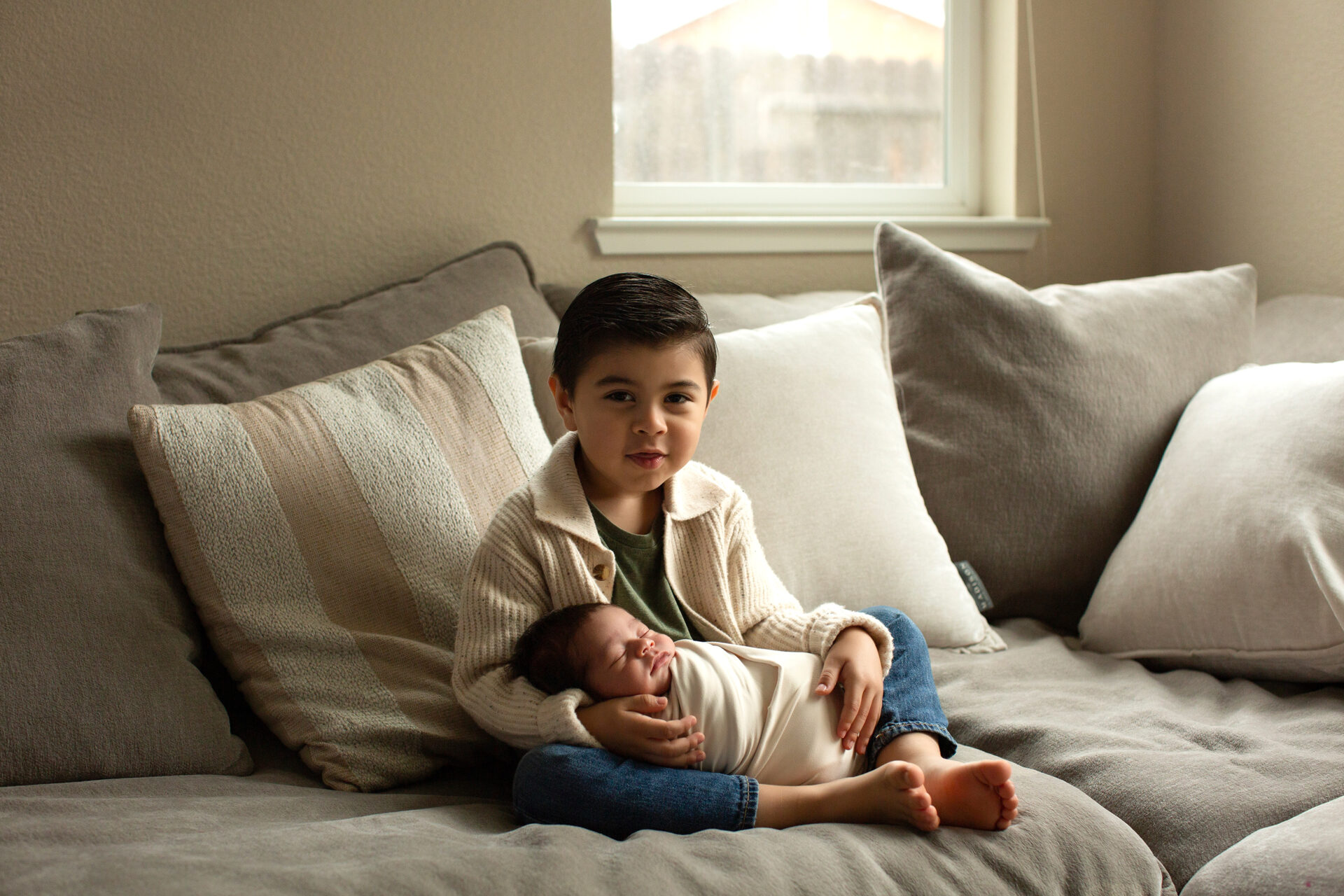big brother holding newborn during in home photoshoot in Roseville, Ca 