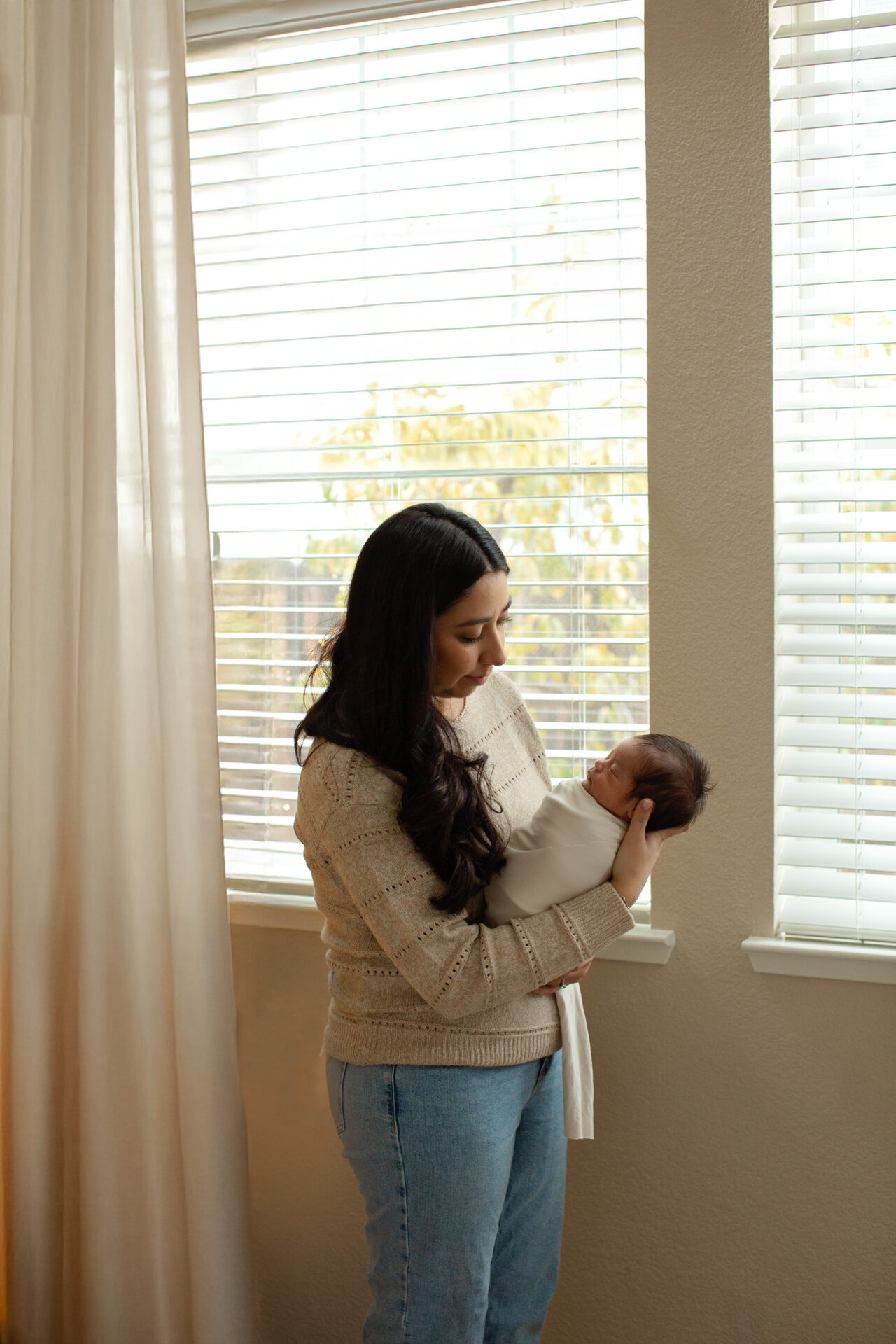 Mother holding newborn baby during Roseville newborn photography session