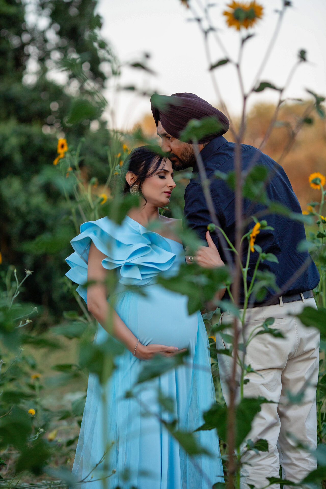 Hands gently resting on a growing baby bump.