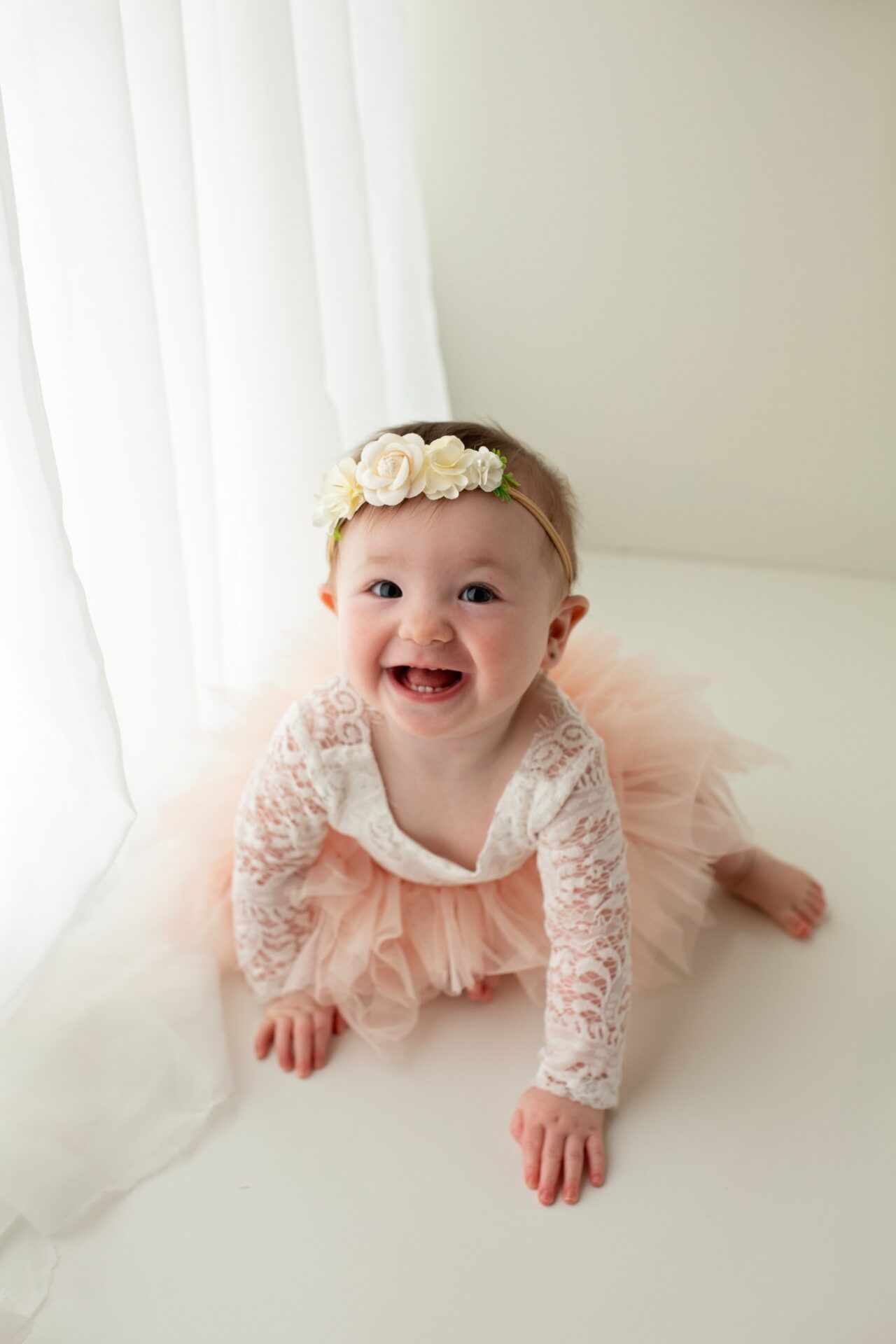 Smiling baby in a blush tutu and floral headband