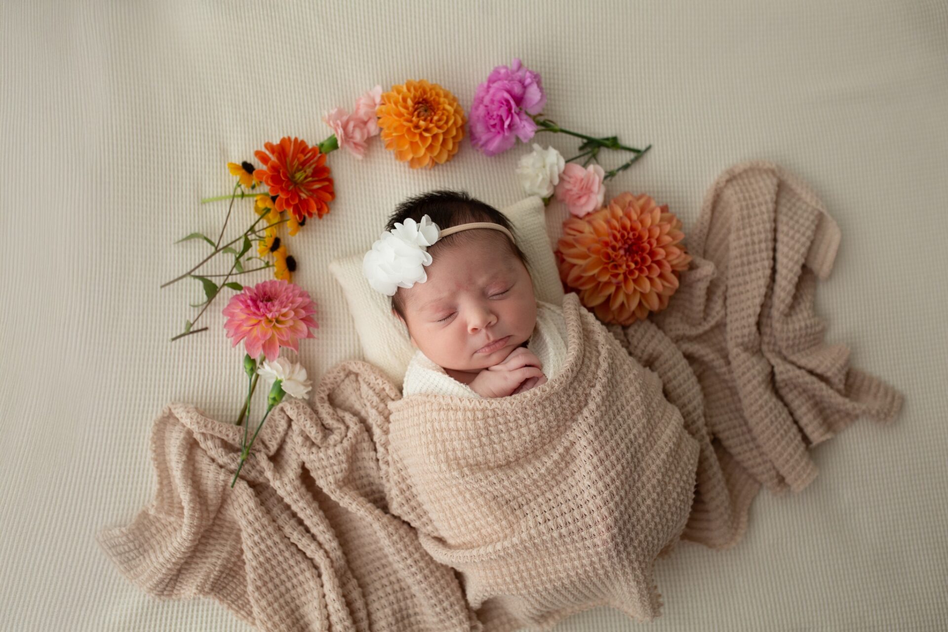 Newborn portrait framed with colorful flowers