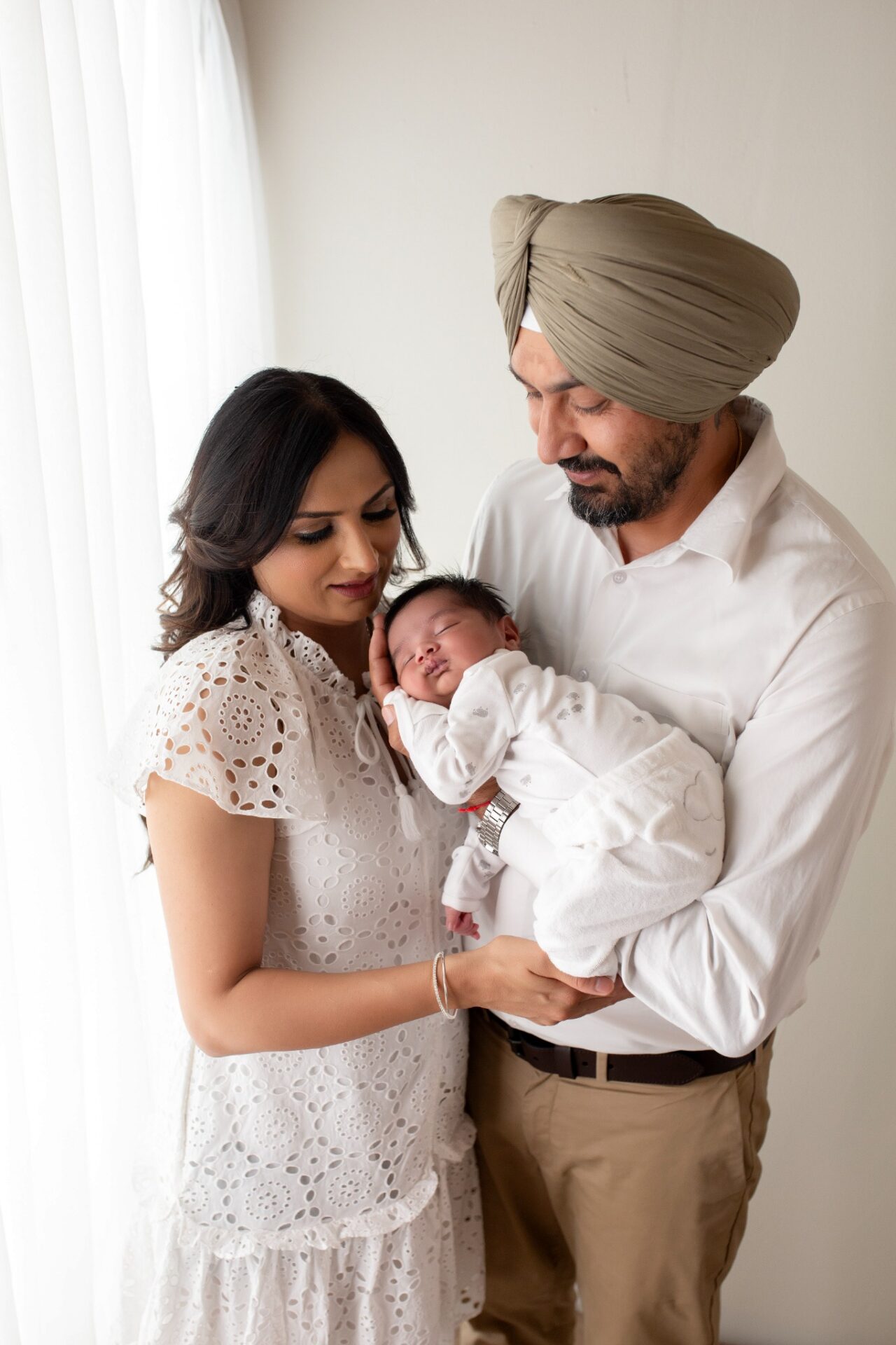 Parents cradling their sleeping baby